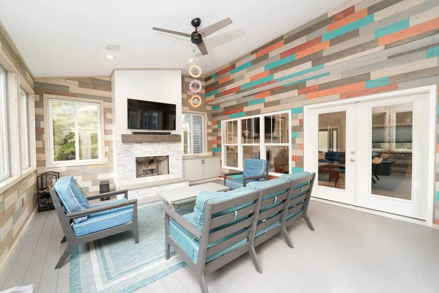 Three-season room with a sofa, accent chairs, and a linear fireplace