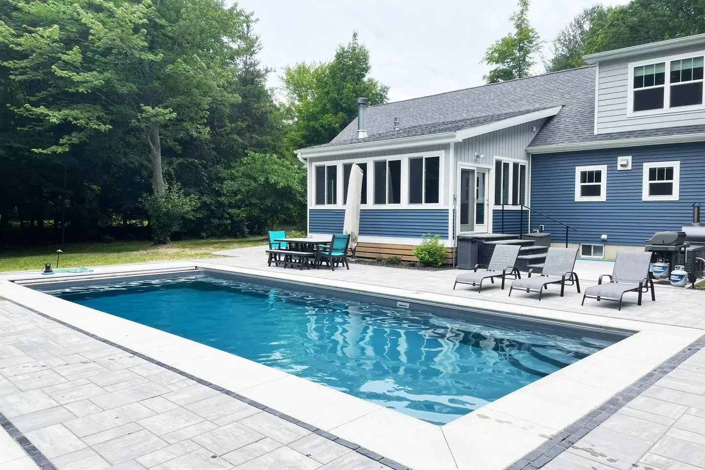 Wide view of the pool with the house beyond, safety cover retracted