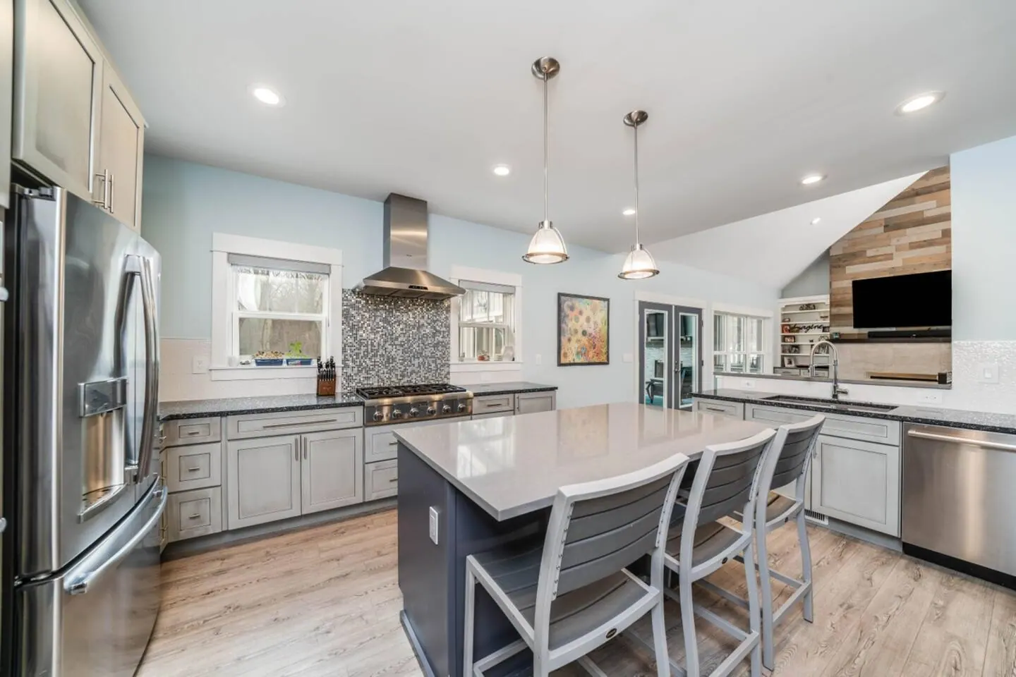 Main kitchen with a long island, bar stools, and full-size appliances