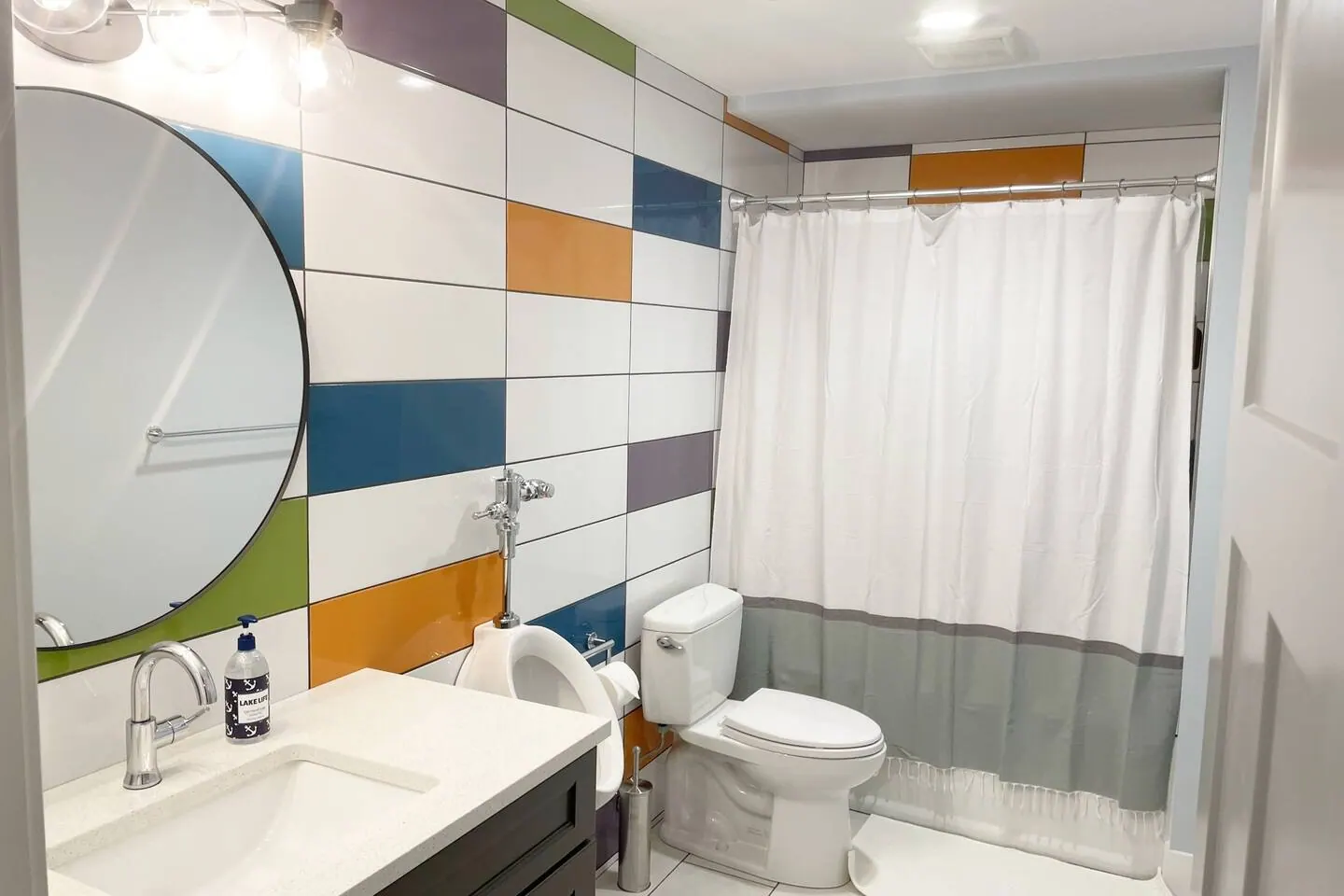 Hall bathroom with a colorful tile accent wall