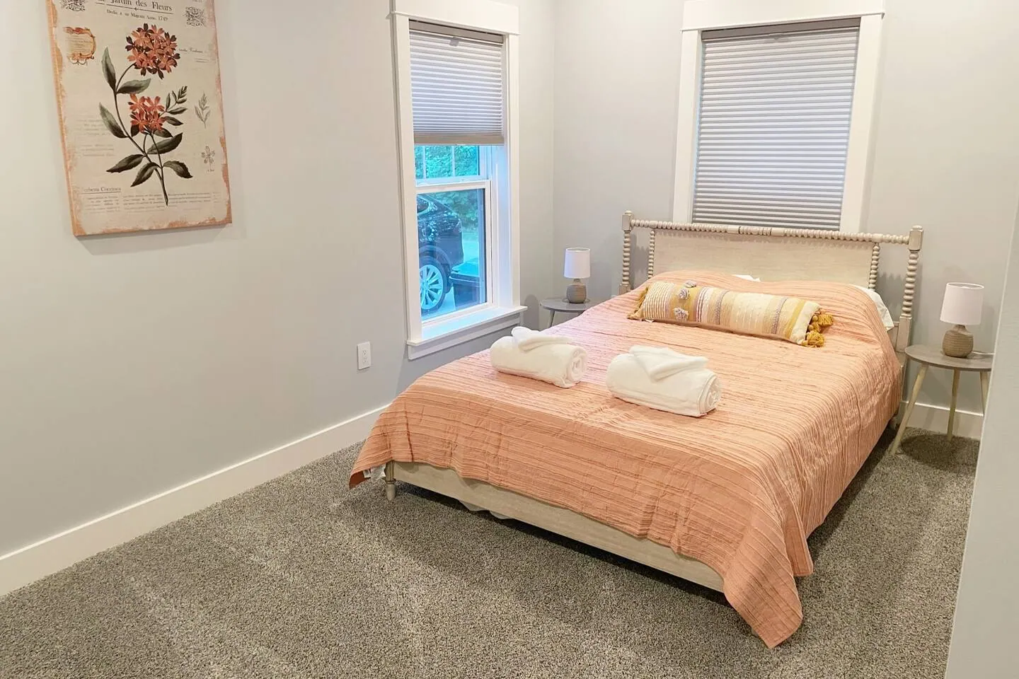 Bedroom with a queen bed dressed in warm peach linens