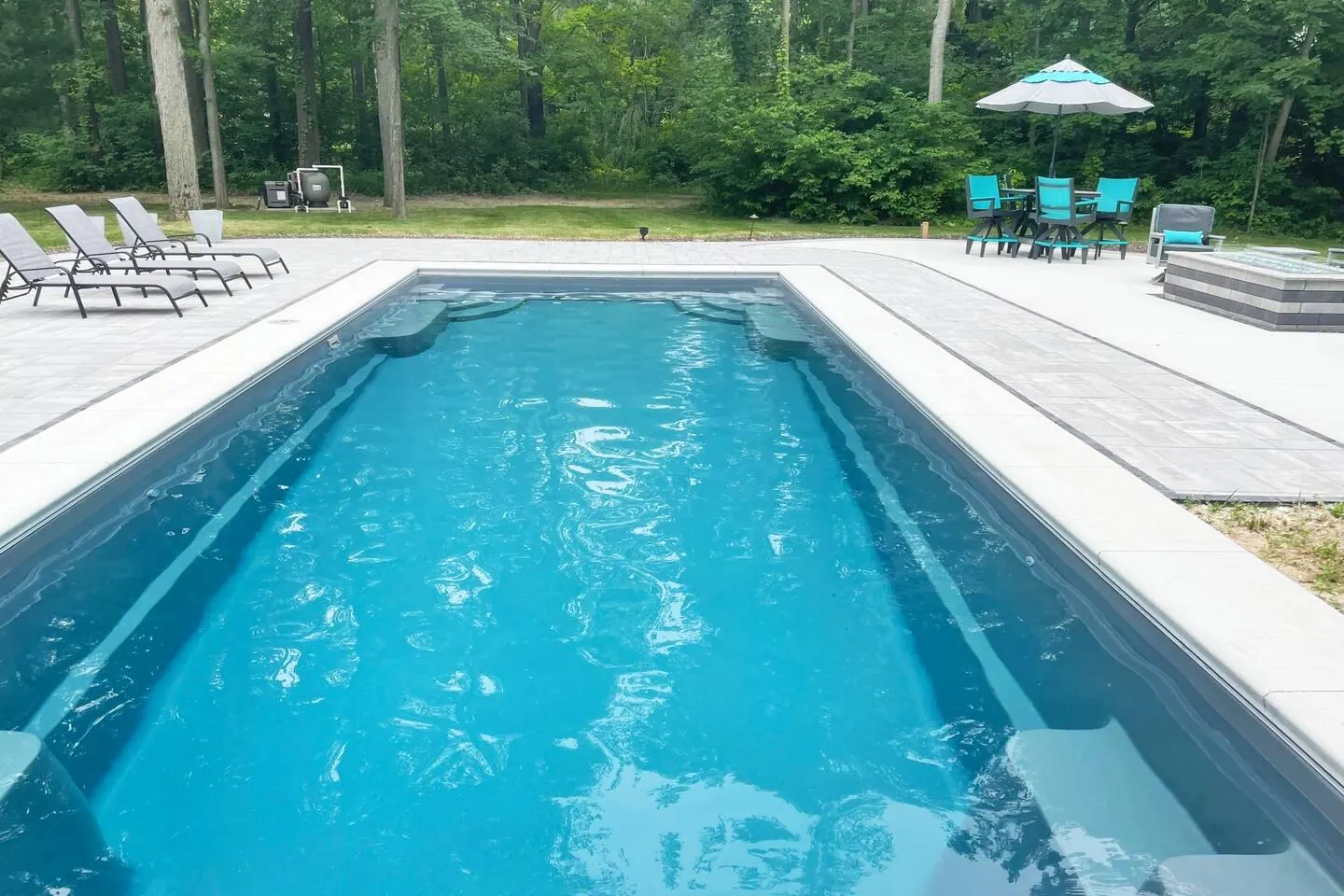 Close view of bright pool water and a single lounge chair