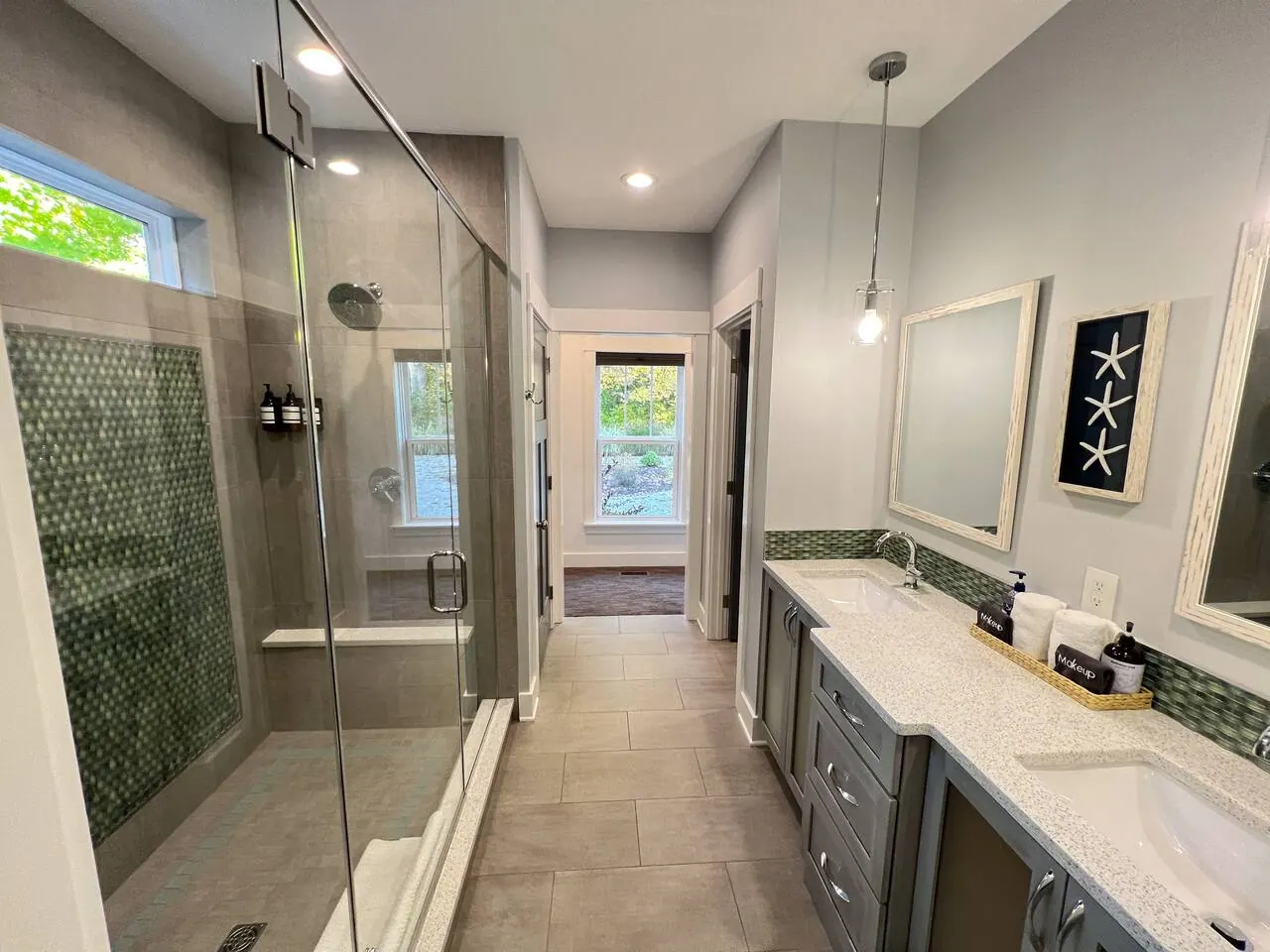 Double vanity bathroom with a window looking toward the pool