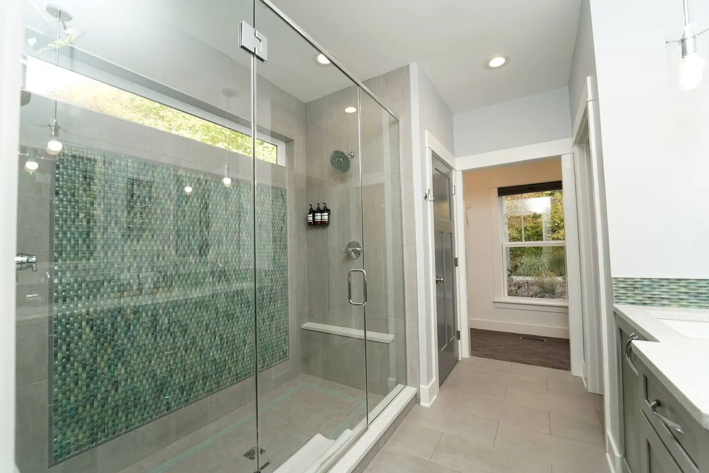 Walk-in shower with two shower heads and pale green tile