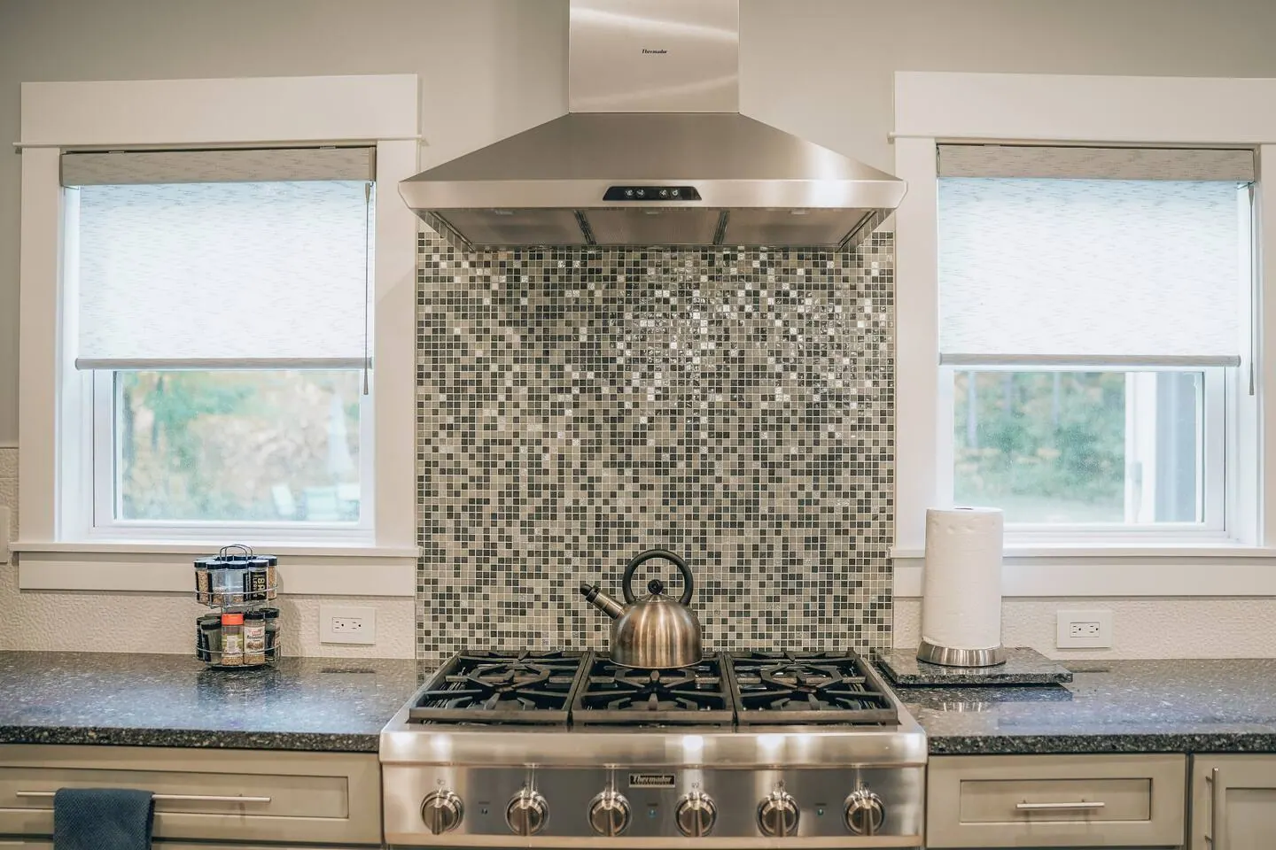Gas range and stone backsplash in the main kitchen