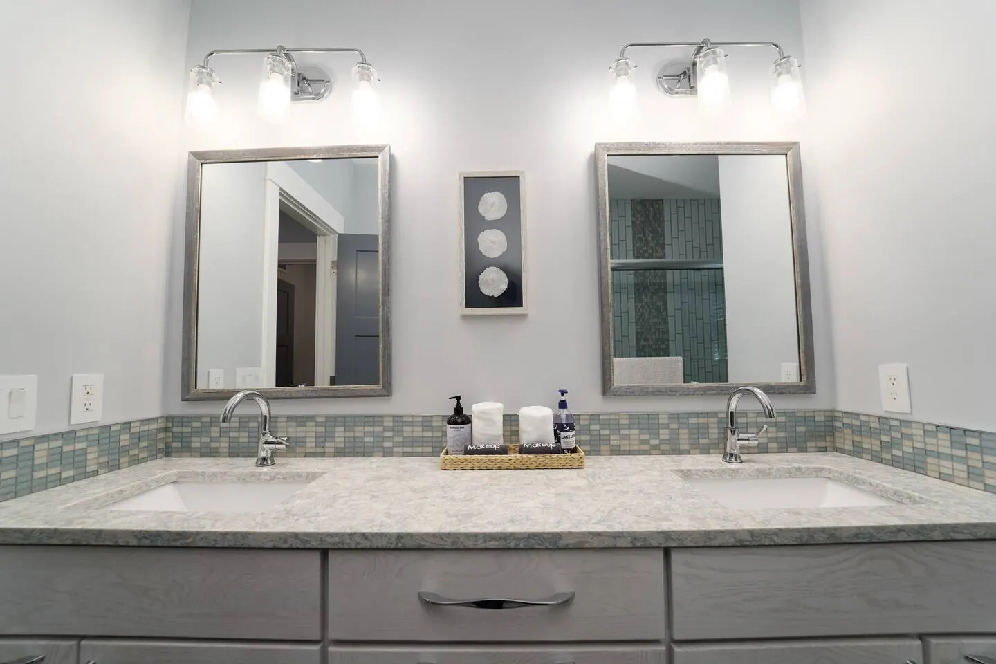 Bright double-sink vanity with round mirrors and globe lights