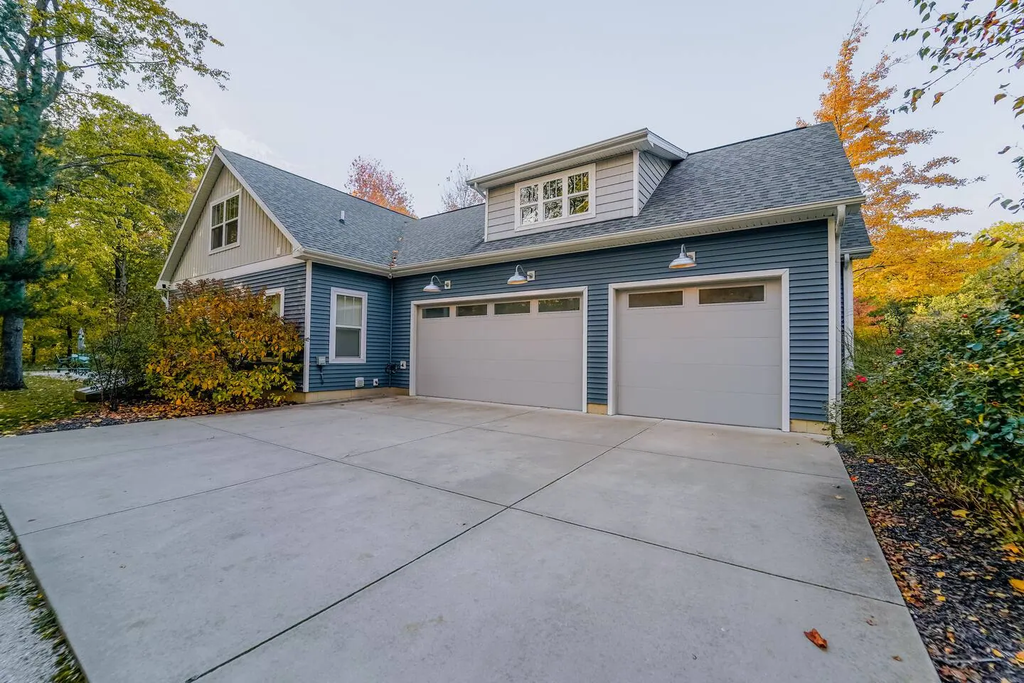 Front of the home with a two-car garage and autumn trees