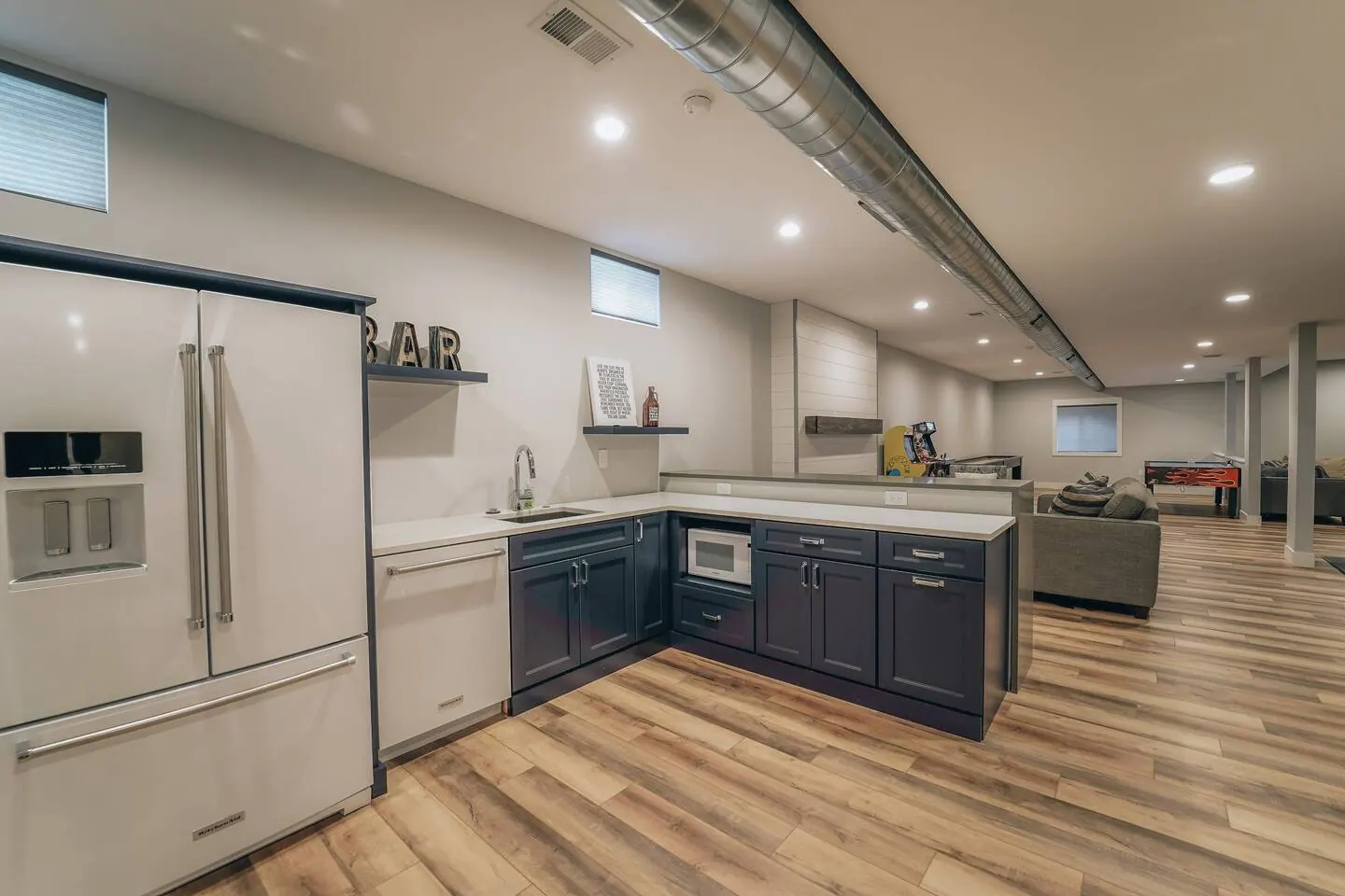 Second full kitchen in the basement with dark cabinets and a long run of counters